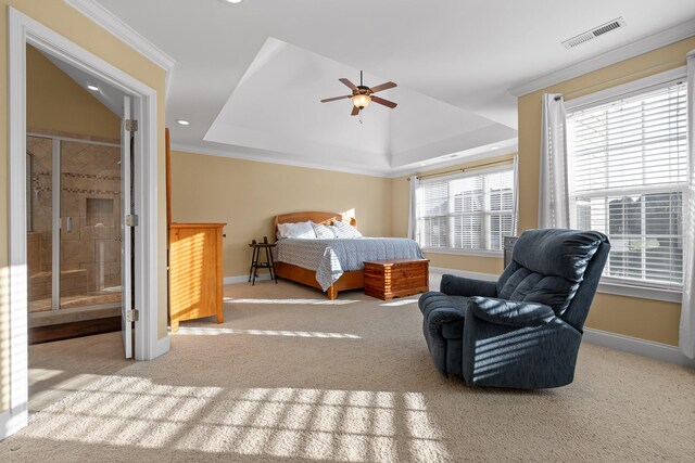 carpeted bedroom featuring crown molding, a raised ceiling, connected bathroom, and ceiling fan