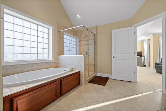 bathroom with tile patterned flooring, separate shower and tub, and vaulted ceiling