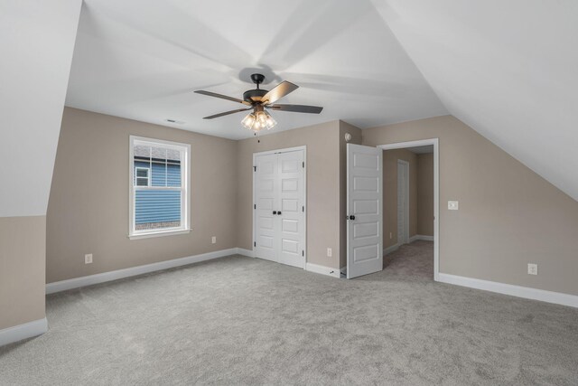 bonus room with ceiling fan, light carpet, and vaulted ceiling