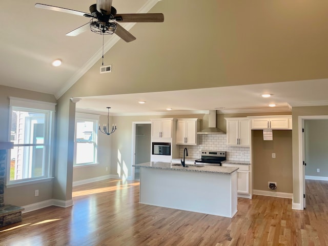 kitchen with electric range, light stone countertops, wall chimney exhaust hood, white cabinets, and light wood-type flooring