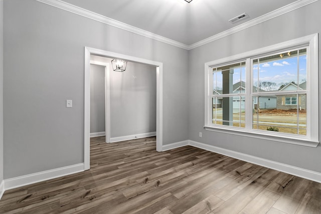 spare room with a notable chandelier, crown molding, and dark hardwood / wood-style flooring