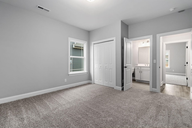 unfurnished bedroom featuring multiple windows, light colored carpet, and a closet