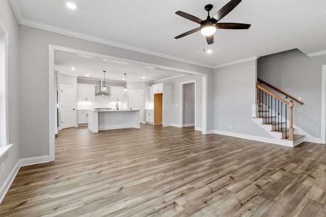 unfurnished living room featuring ceiling fan, crown molding, and light hardwood / wood-style floors