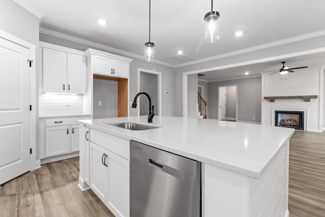 kitchen with sink, dishwasher, hanging light fixtures, and white cabinets