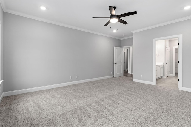 unfurnished bedroom featuring ceiling fan, ensuite bathroom, light colored carpet, and ornamental molding