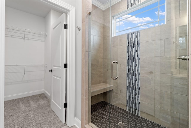 bathroom with crown molding and a shower with door