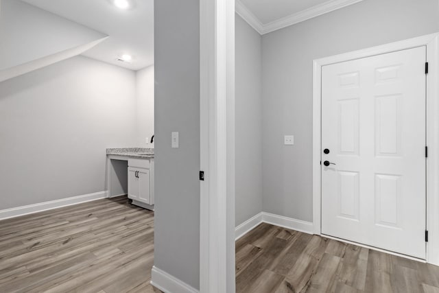 foyer entrance with crown molding and light hardwood / wood-style floors