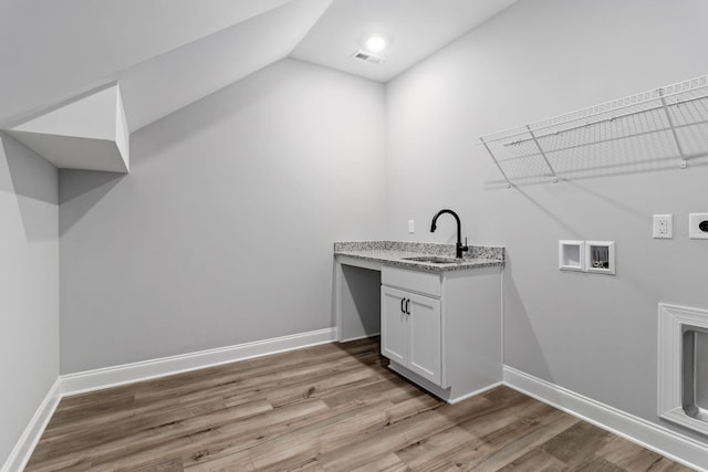 clothes washing area featuring sink, electric dryer hookup, light hardwood / wood-style floors, and washer hookup