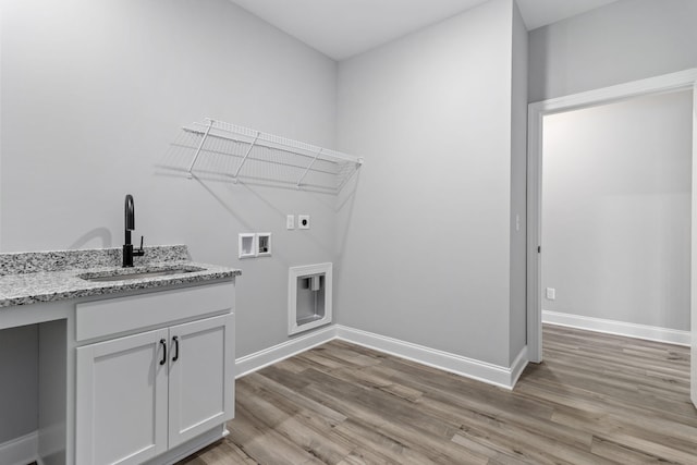 laundry area with sink, light wood-type flooring, hookup for an electric dryer, and washer hookup