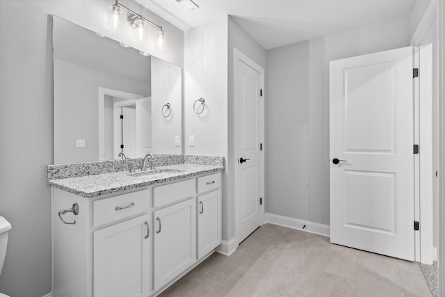 bathroom featuring toilet, vanity, and tile patterned flooring