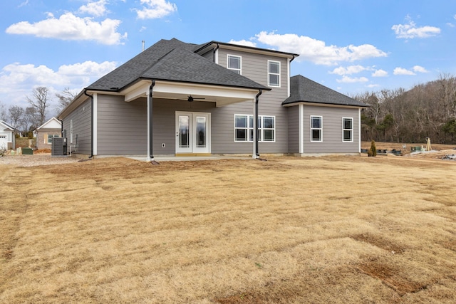 rear view of property with ceiling fan, central AC unit, and a yard