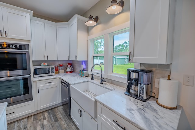 kitchen featuring decorative backsplash, stainless steel appliances, and white cabinets