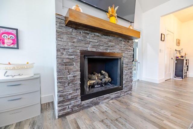 details featuring a fireplace, baseboards, and wood finished floors