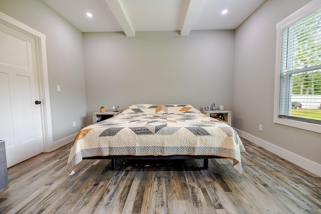 bedroom with beamed ceiling, recessed lighting, baseboards, and wood finished floors