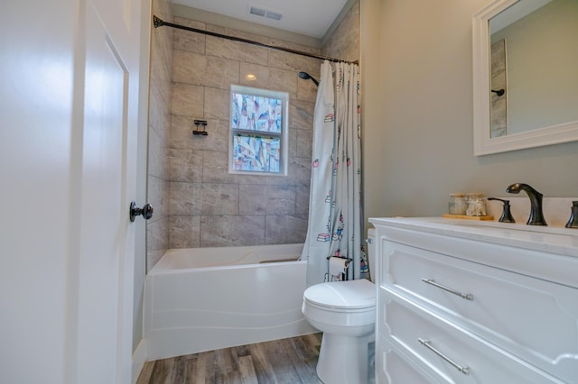 full bathroom with visible vents, toilet, shower / bath combo, wood finished floors, and vanity