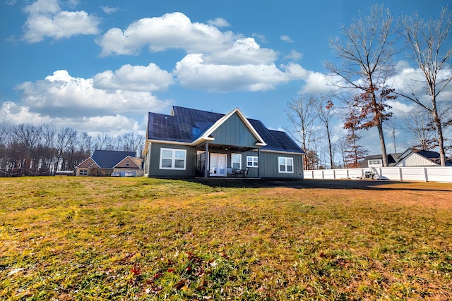 rear view of property featuring a lawn