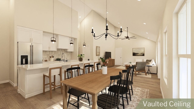 dining area featuring sink, light hardwood / wood-style flooring, high vaulted ceiling, and ceiling fan