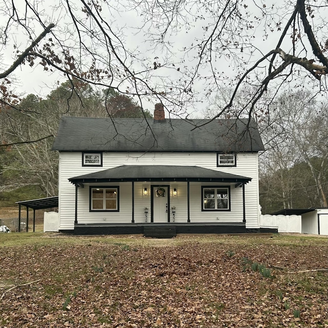 view of front of house featuring a storage shed, a carport, and covered porch