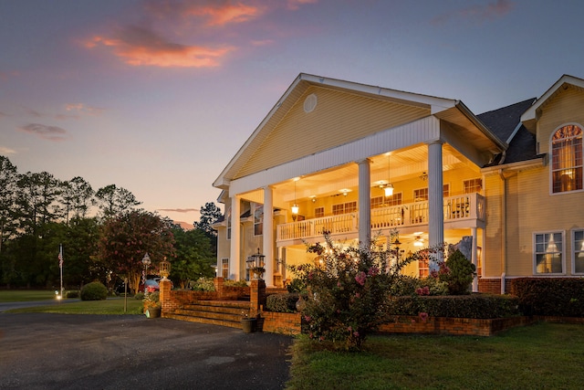 view of front of house featuring a balcony and a yard