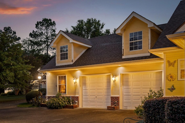 view of front of home featuring brick siding, driveway, roof with shingles, and an attached garage