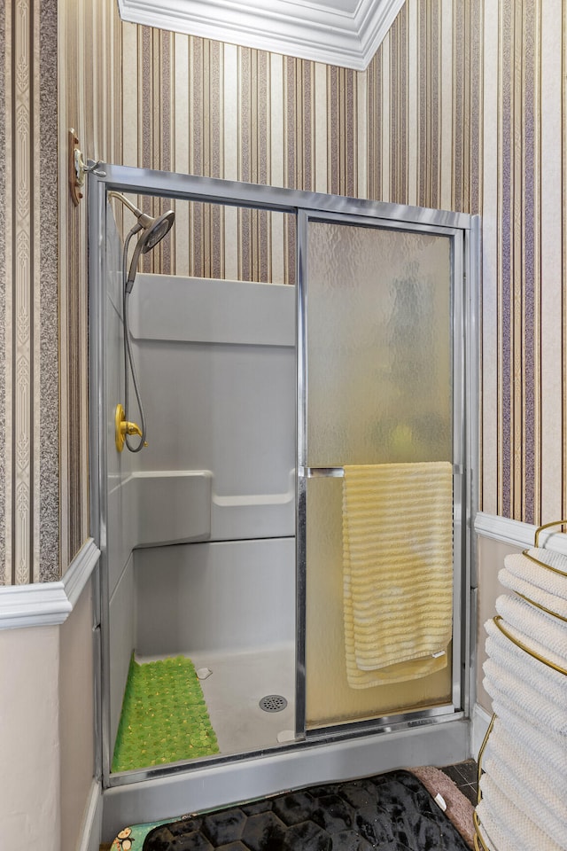 bathroom with ornamental molding and a shower with shower door