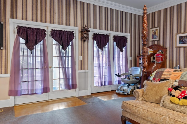 doorway featuring baseboards, ornamental molding, wallpapered walls, and wood finished floors