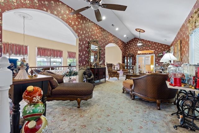 carpeted living area with wallpapered walls, arched walkways, lofted ceiling, and ceiling fan