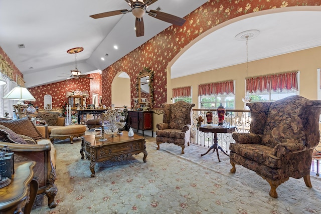 carpeted living area featuring a ceiling fan, lofted ceiling, visible vents, wallpapered walls, and arched walkways