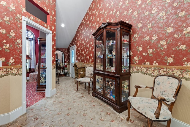 hallway with carpet flooring, wallpapered walls, vaulted ceiling, and plenty of natural light