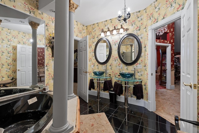 bathroom with baseboards, wallpapered walls, a sink, and ornate columns