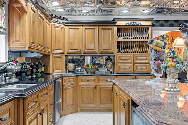 kitchen featuring an ornate ceiling, brown cabinetry, and dark stone countertops