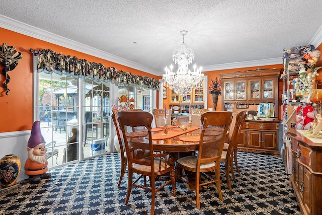 dining area featuring an inviting chandelier, carpet flooring, ornamental molding, and a textured ceiling