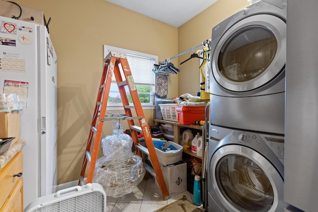 clothes washing area with stacked washer / dryer, laundry area, and tile patterned flooring