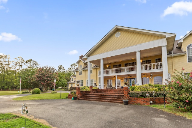 view of front facade with covered porch and a balcony