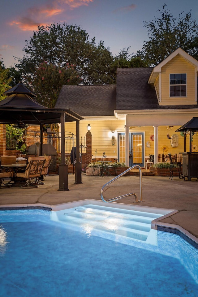 pool at dusk featuring a patio, french doors, and a fenced in pool