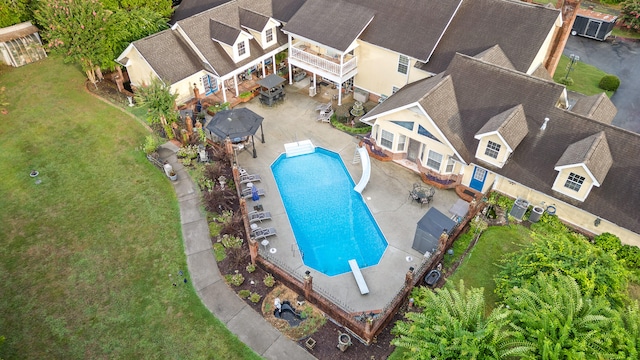 exterior space with a water slide, a diving board, a lawn, and a patio area