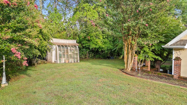 view of yard with an outdoor structure and a greenhouse