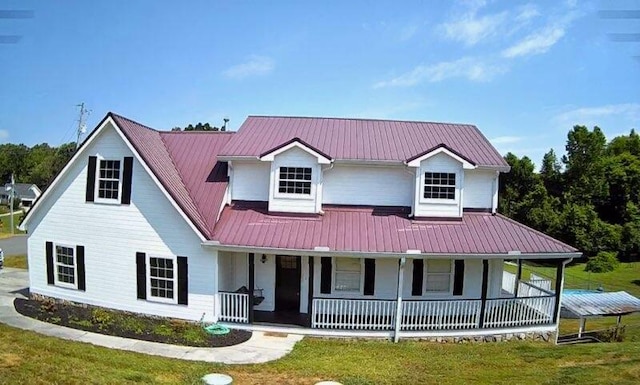 farmhouse inspired home with a front lawn and a porch