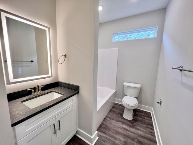 bathroom featuring wood-type flooring, vanity, a bathtub, and toilet