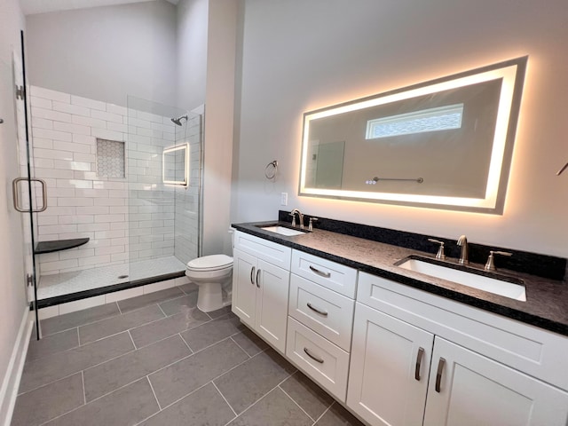 bathroom featuring tile patterned flooring, a shower with shower door, vanity, and toilet