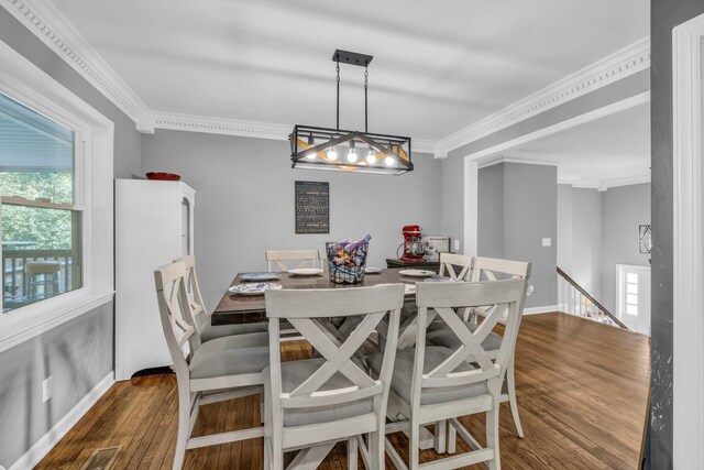 dining space featuring dark hardwood / wood-style flooring, a chandelier, and crown molding