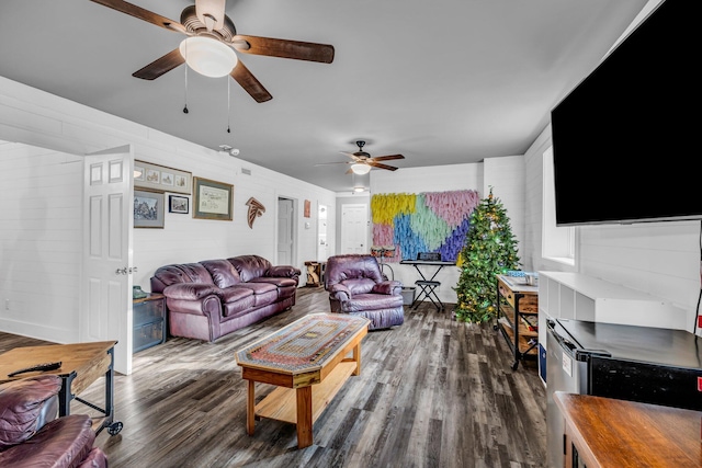 living room featuring dark wood-type flooring and ceiling fan