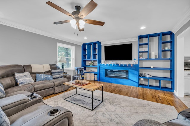 living room featuring light hardwood / wood-style floors, ceiling fan, and ornamental molding