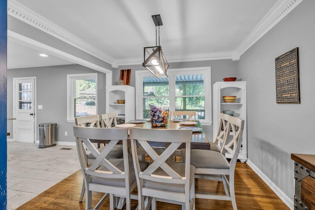 dining space featuring light hardwood / wood-style floors and crown molding