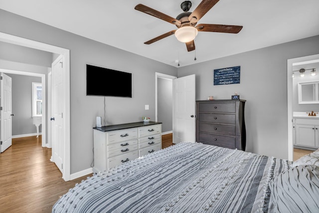 bedroom with light hardwood / wood-style flooring, ceiling fan, sink, and connected bathroom