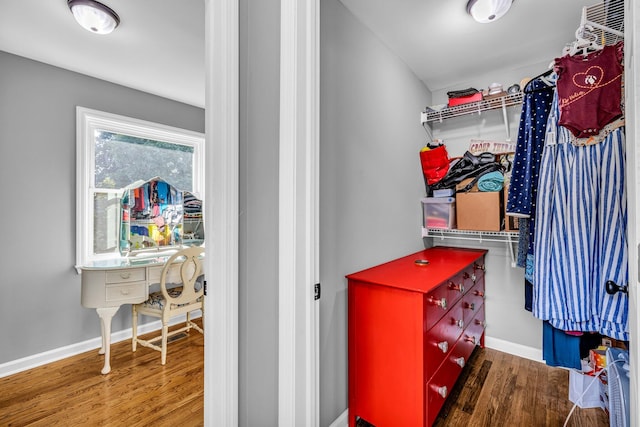 walk in closet with dark wood-type flooring