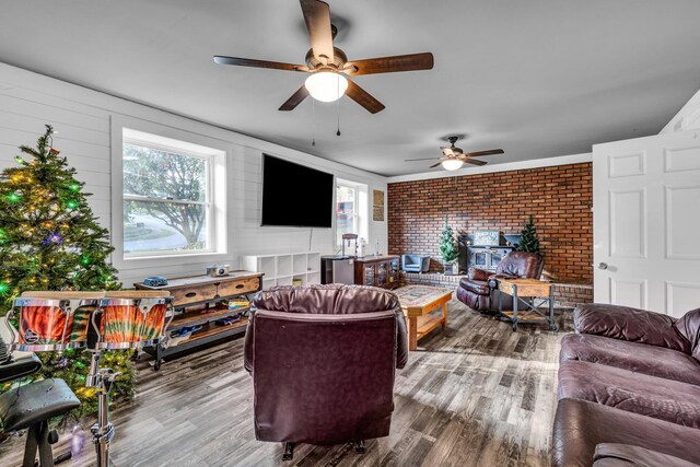 living room featuring brick wall, hardwood / wood-style flooring, and ceiling fan