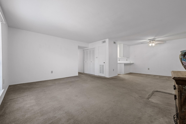 unfurnished living room with carpet and ceiling fan