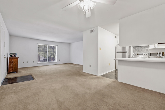 unfurnished living room featuring ceiling fan and carpet floors