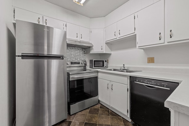 kitchen with appliances with stainless steel finishes, white cabinetry, sink, and decorative backsplash